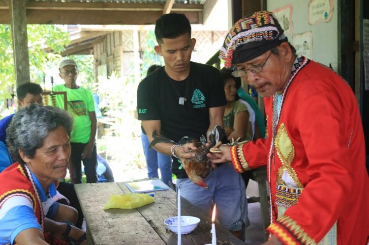Indigenous youth assist their traditional leader in a ritual