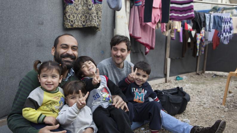 Father and kids laughing in a refugee camp in Akkar 