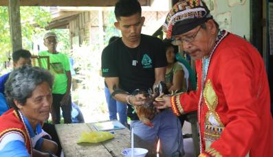 Indigenous youth assist their traditional leader in a ritual