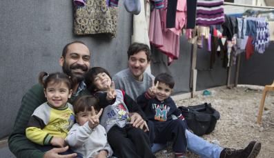 Father and kids laughing in a refugee camp in Akkar 