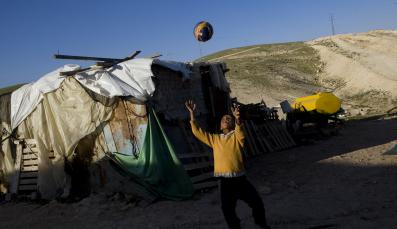 Ein Junge spielt Ball vor seinem Haus in Khan al Ahmar, Palästina