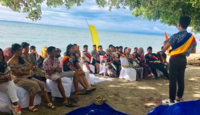 Members of the Responsible Young Leaders Organization listen to a speaker on the beach