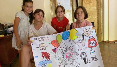 Children in Ukraine hold up a poster they designed