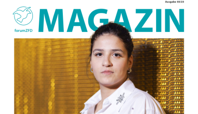 Titelbild des Magazins Ausgabe 3 2023. Eine junge Frau in weißer Bluse vor einem gold schimmernden Vorhang