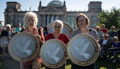 Drei Aktivistinnen bei der Protestaktion "Frieden gibt es nicht umsonst"